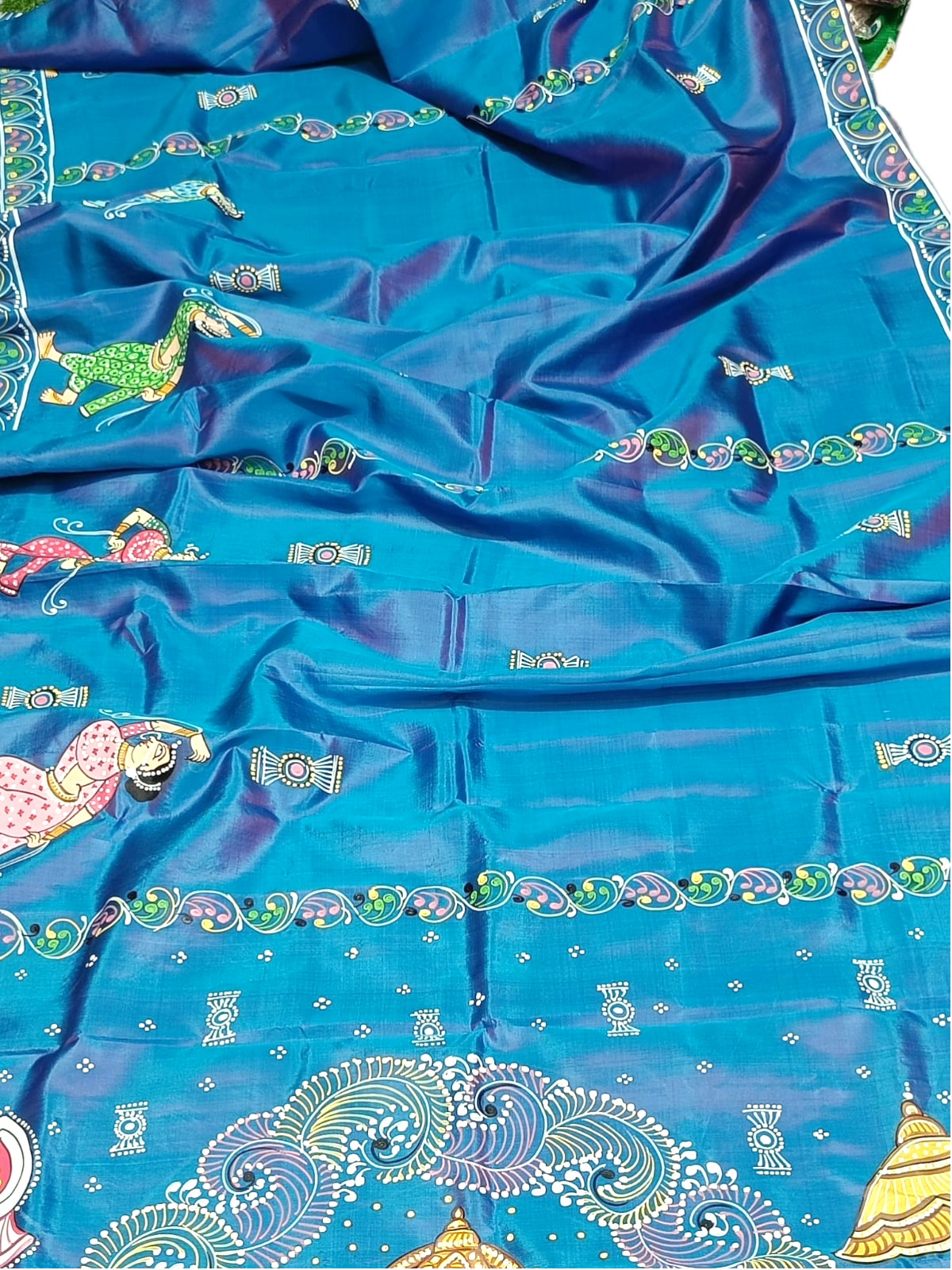 Blue silk saree with hand-painted Pattachitra design featuring Krishna Leela motifs and floral borders.