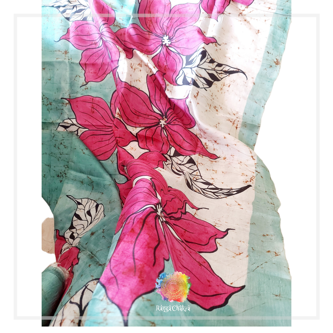 Floral batik silk saree with pink flower design on teal and white.