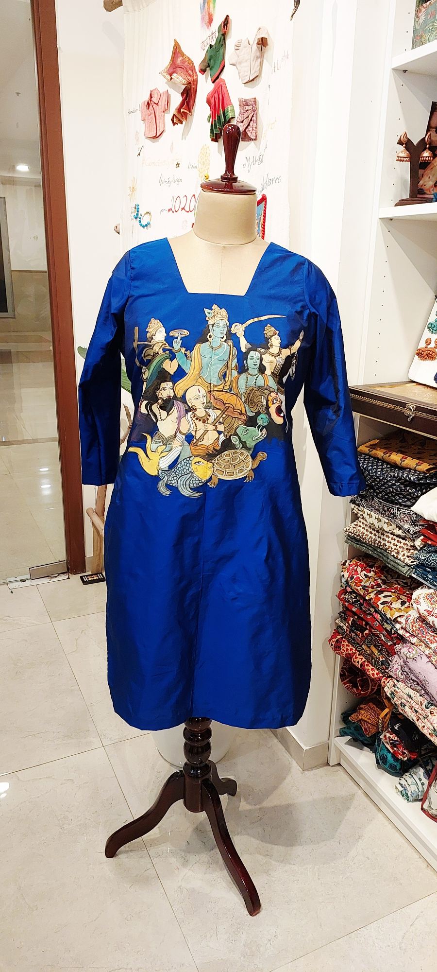 Discover the Dashavatara Handpainted Silk Kurti in Royal Blue. A stunning, handcrafted tribute to the ten avatars of Lord Vishnu. Made from 100% pure silk, this unique designer tunic is perfect for festive occasions and spiritual gatherings. Shop the collection today!